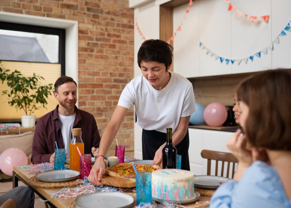 A woman presenting food at a birthday party, illustrating how to plan a perfect celebration on a budget with expert advice.